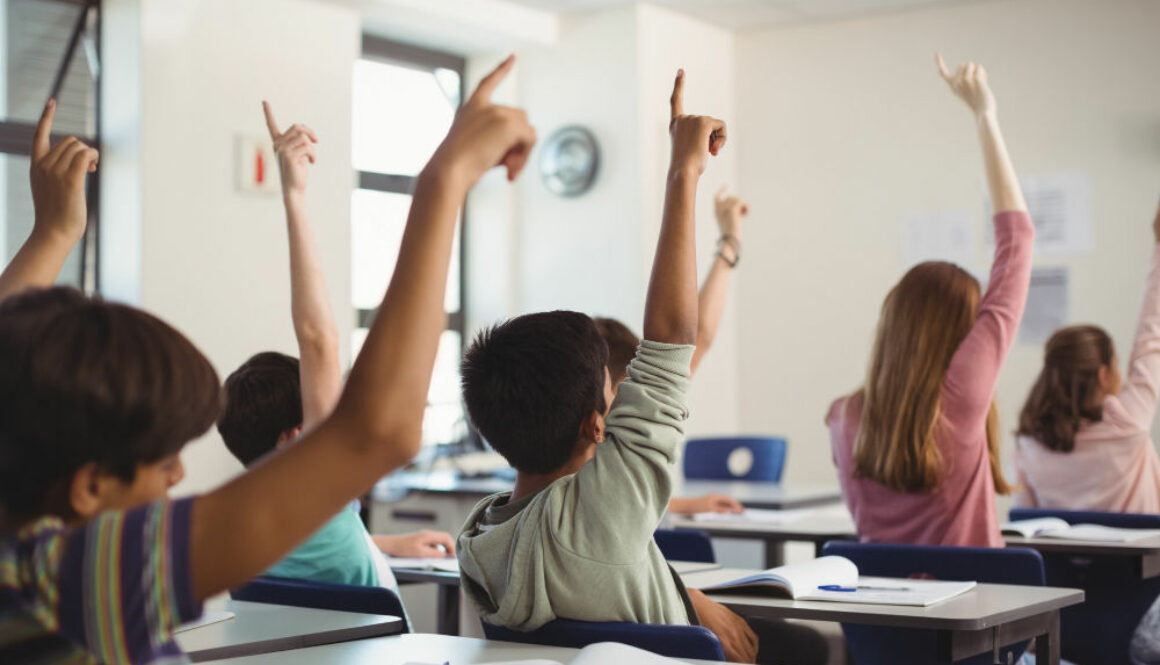 85511School kids raising hand in classroom